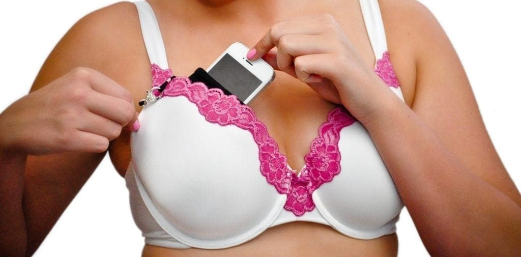 Woman Putting Mobile Phone Into Her Bra For Safe Keeping Stock